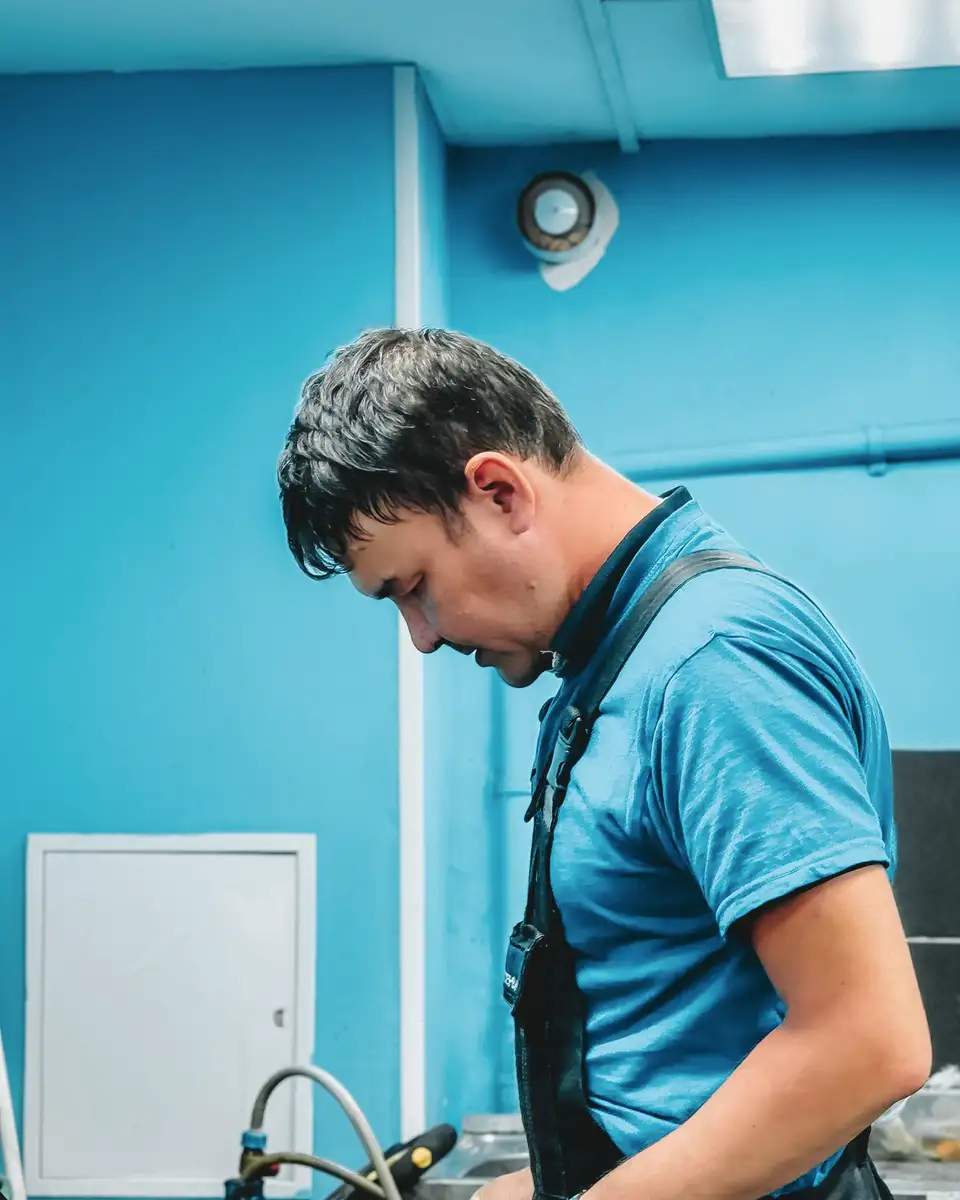 Plumber at work in a blue workshop