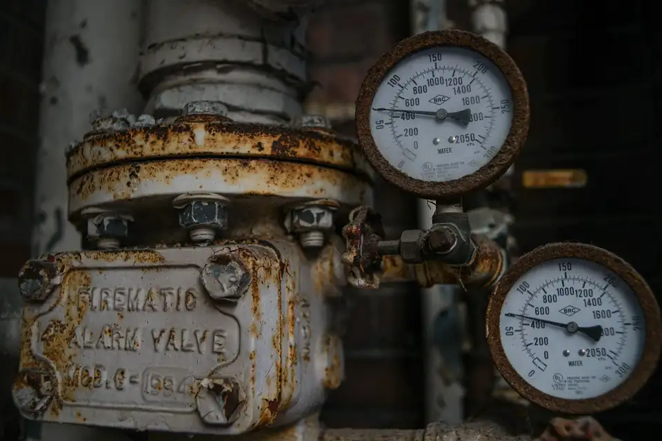Old corroded valve and gauges on aged pipework